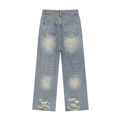 Vintage wash distressed denim jeans by ODMPOD, showcasing a classic fit with faded, torn details and a casual, rugged style.