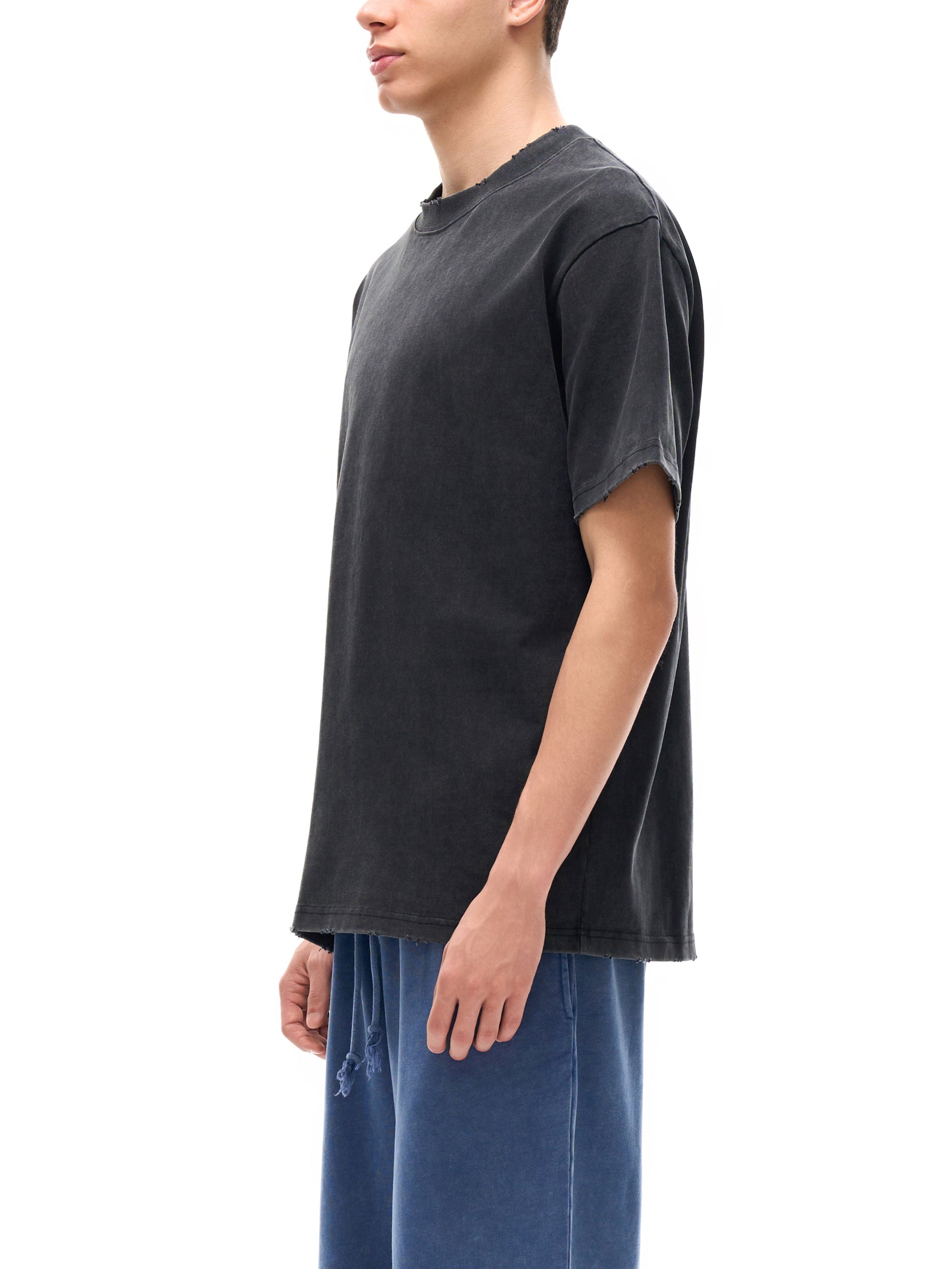 Vintage washed heavyweight ODMPOD T-shirt with frayed edges and distressed details, showcasing a casual, rugged style.