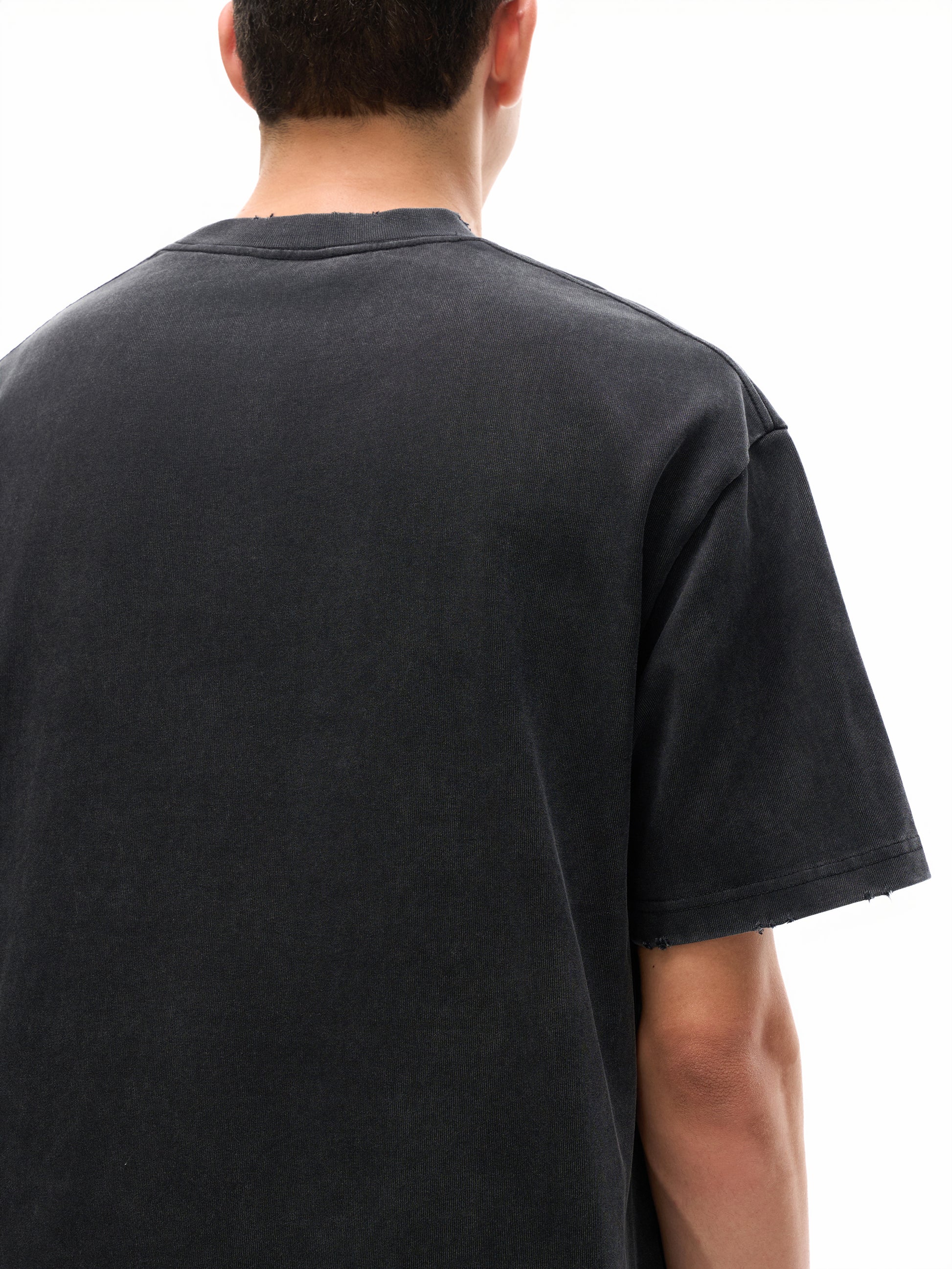 Vintage washed heavyweight ODMPOD frayed T-shirt displayed on a hanger with a worn, casual look and distressed fabric details.