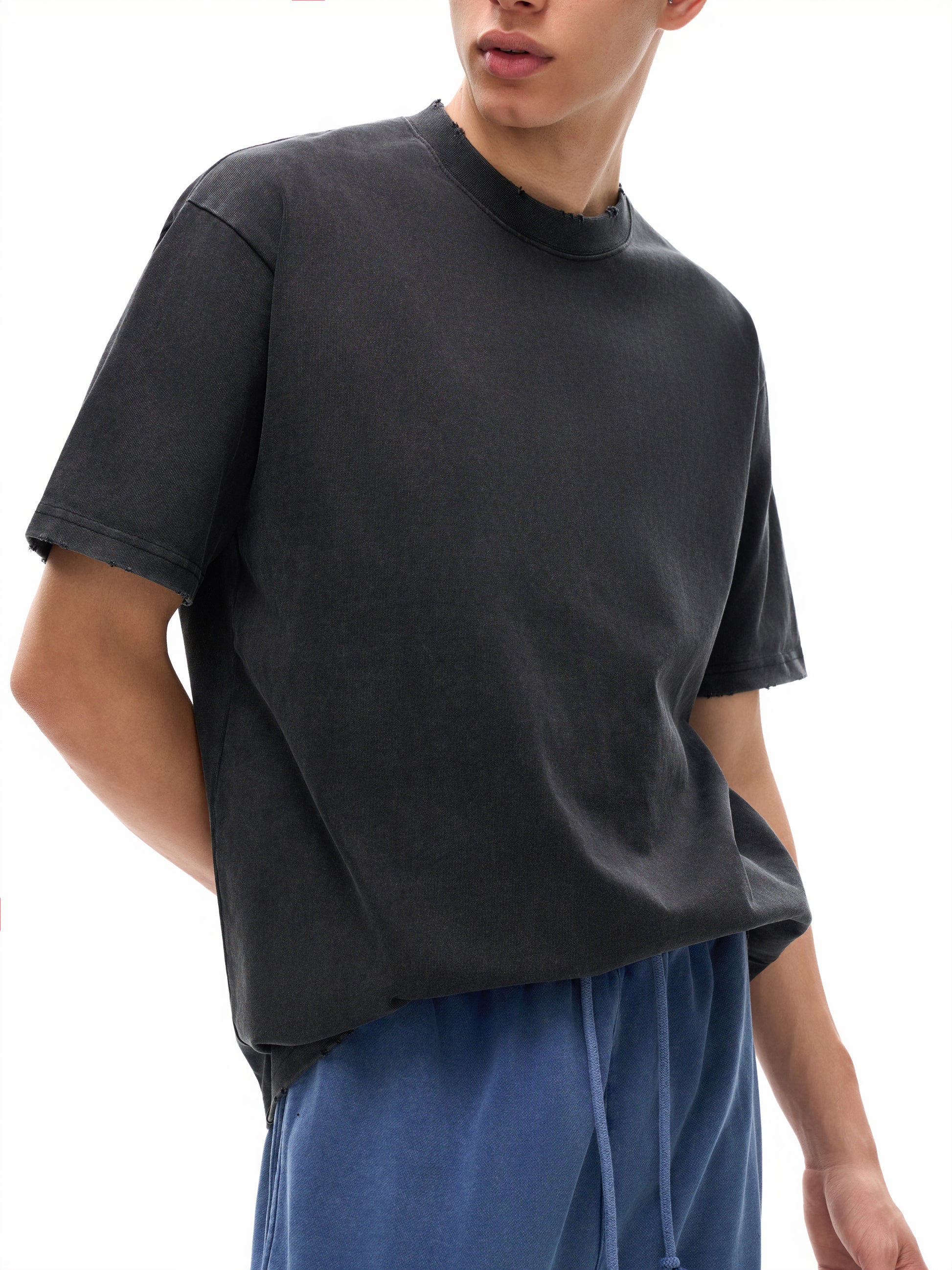 Heavyweight vintage washed frayed T-shirt by ODMPOD with distressed details and a relaxed fit, displayed on a plain background.