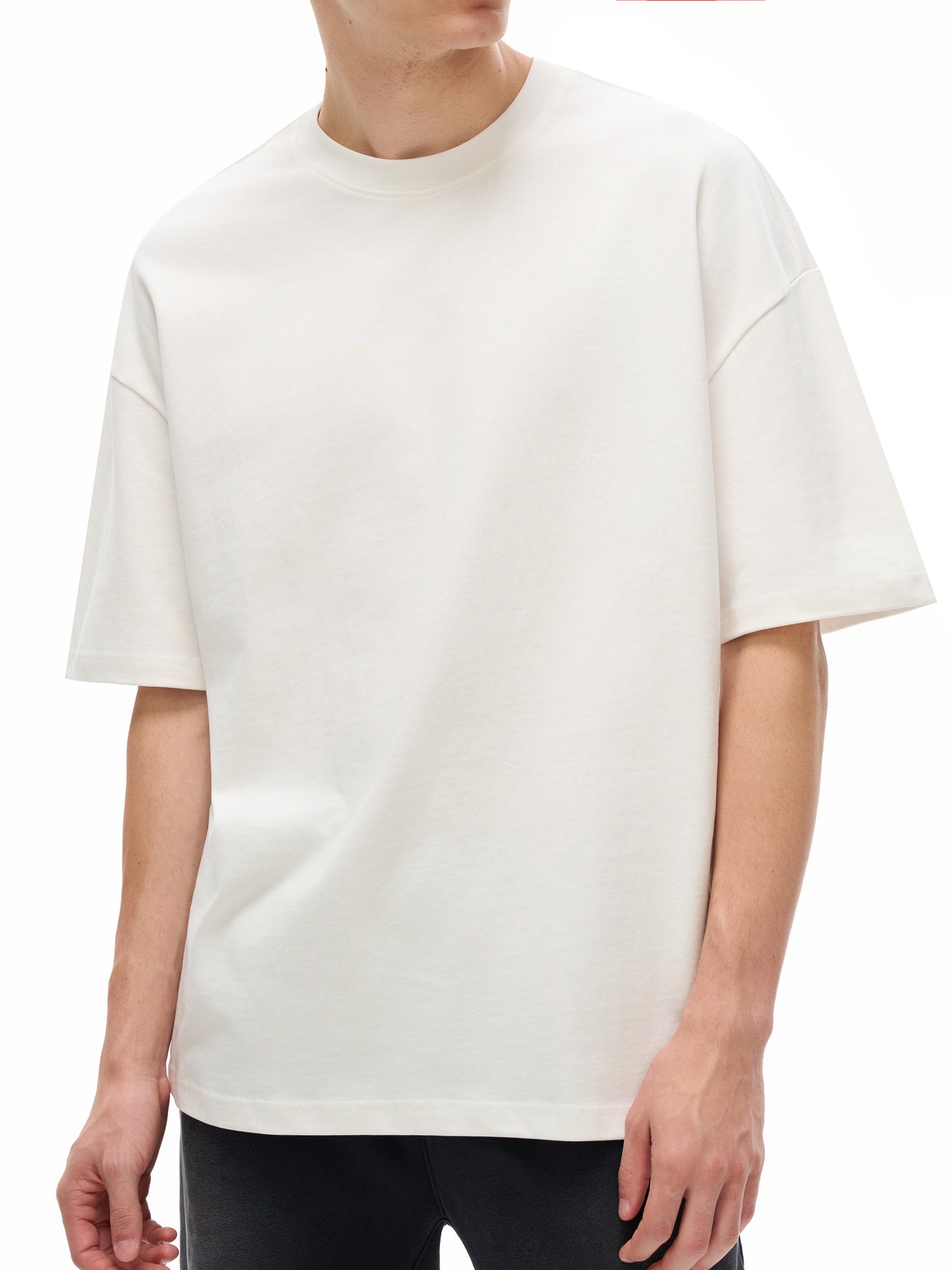 White ODMPOD Essential Heavyweight Cotton T-shirt laid flat, showing the front design and soft, thick fabric.
