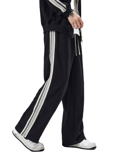 ODMPOD contrast side-stripe straight-leg pants shown on model, featuring sleek design and bold side stripe details.