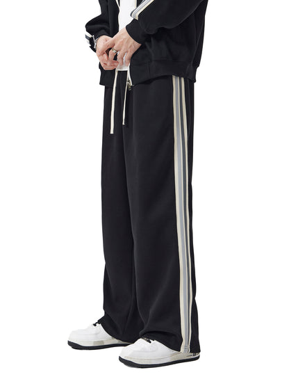 ODMPOD contrast side-stripe straight-leg pants showing a close-up of the fabric and side stripe detail.
