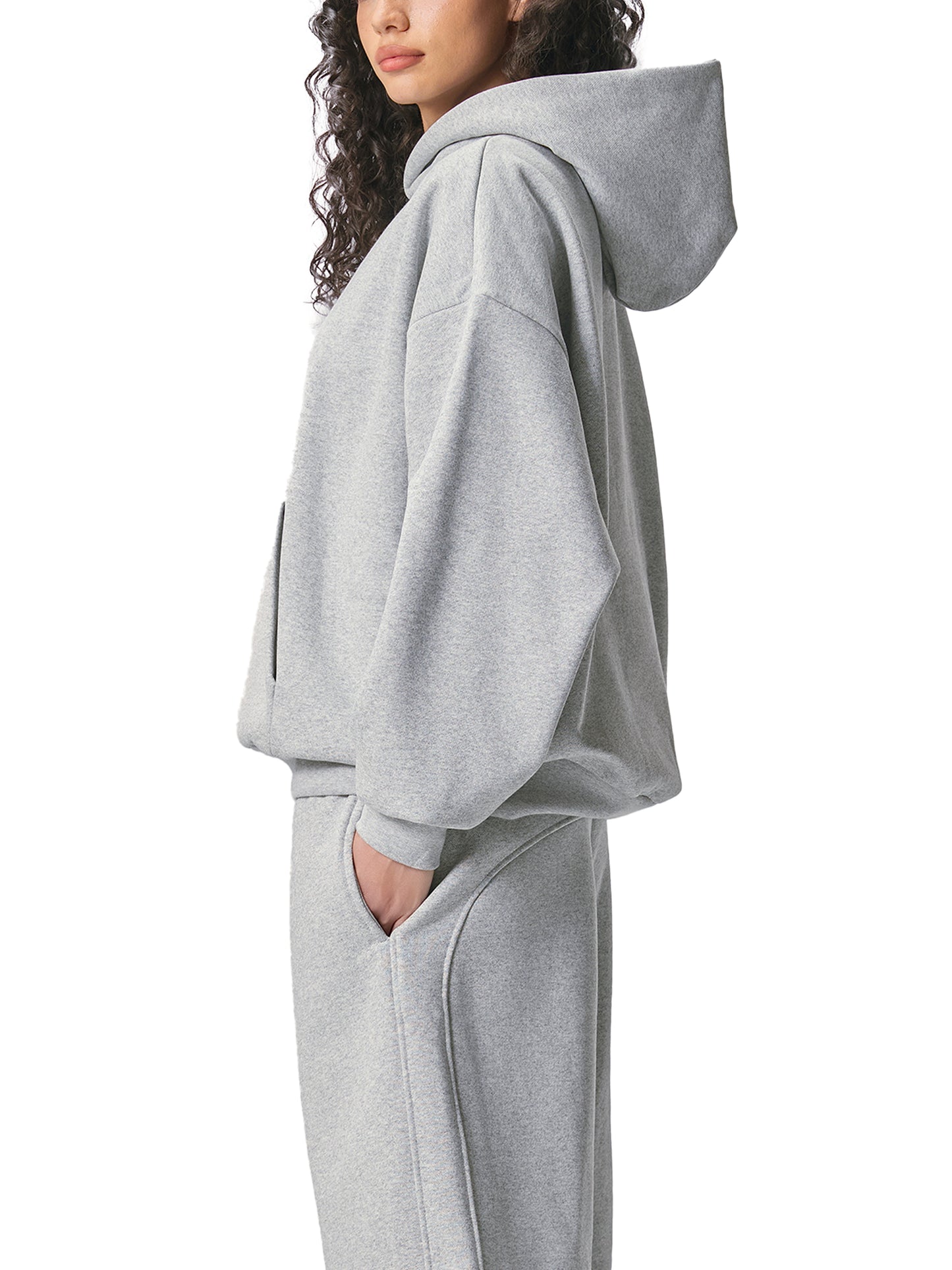 ODMPOD Essential heavyweight fleece hoodie in black with a front kangaroo pocket and adjustable drawstrings, worn by a person.