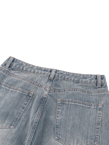 Vintage wash distressed denim jeans by ODMPOD, featuring a classic fit with intentional fading and frayed detailing.