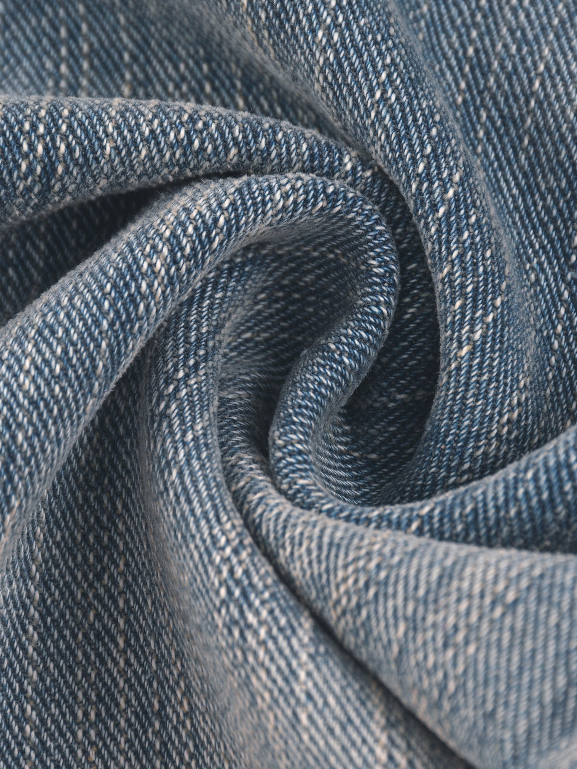 Vintage wash distressed denim jeans by ODMPOD, showing a close-up of the faded, ripped fabric and classic jean stitching.