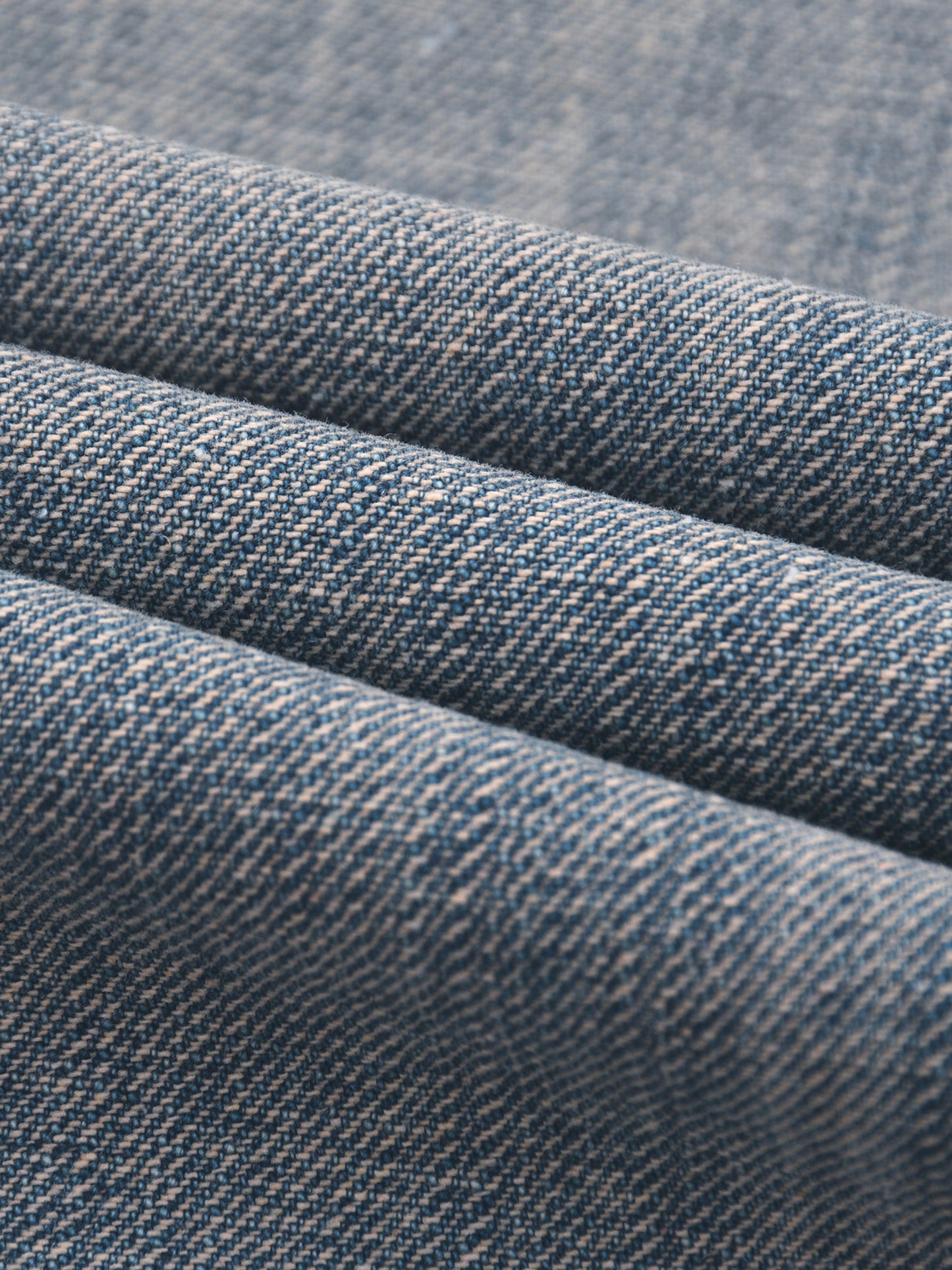 Vintage wash distressed denim jeans by ODMPOD, showing a close-up of the faded, ripped denim fabric and classic jean stitching.