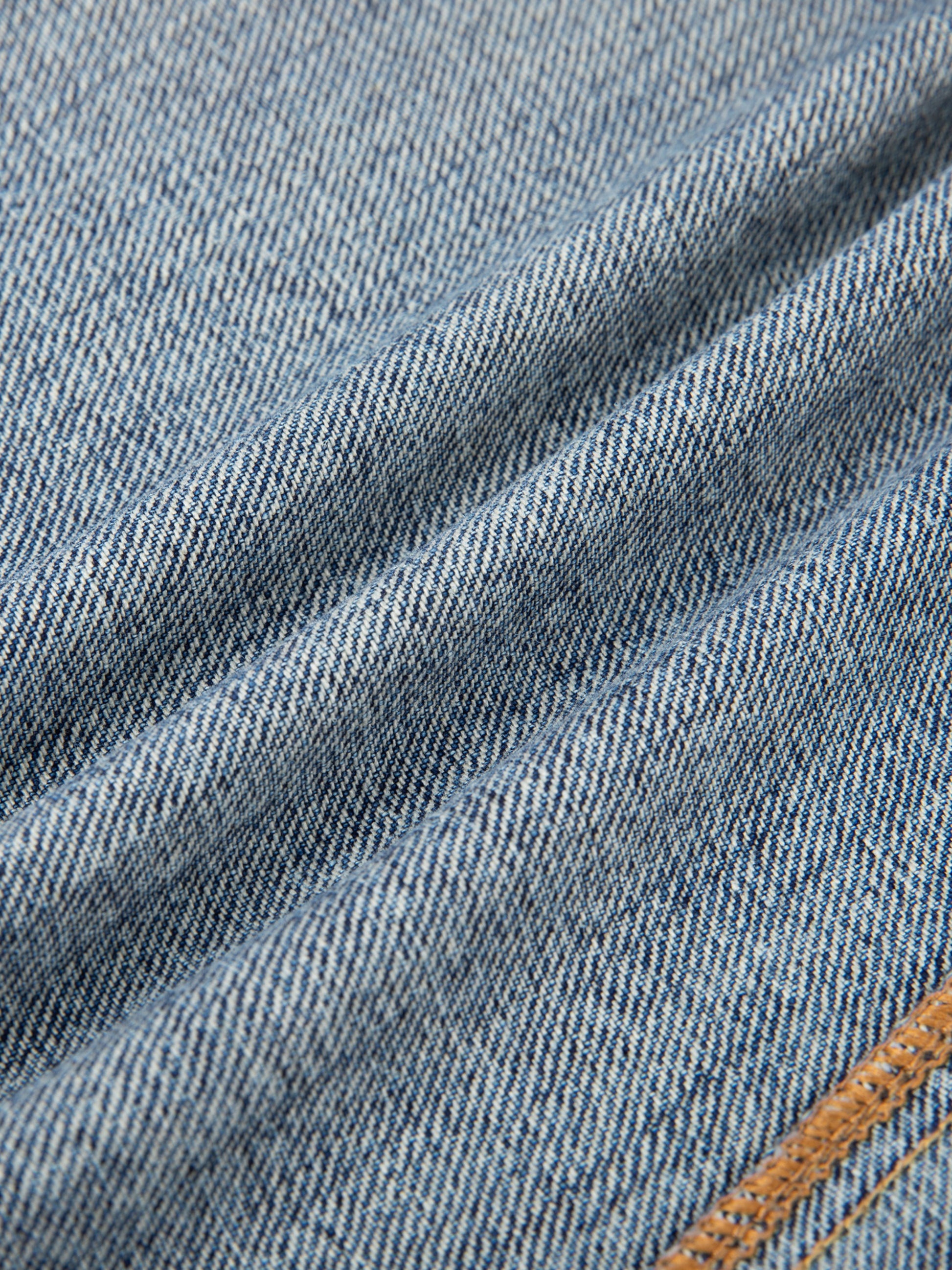 Vintage wash baggy denim jeans by ODMPOD, showing relaxed fit, faded indigo fabric, and classic five-pocket design.